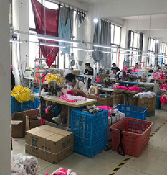 Swimwear production line with operators working on bright stretch garments