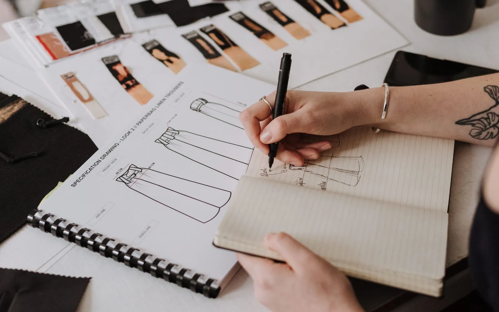 Designer adding clear notes to a garment sketch