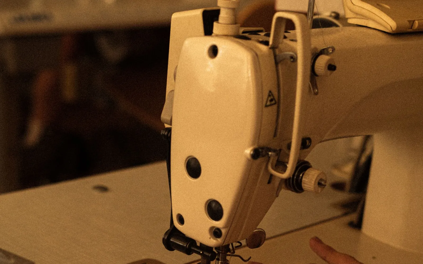 Hands guiding fabric through an industrial sewing machine